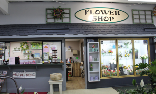 Our Flower Shop located inside the store, featuring a display of bouquets and flower arrangements. To the left, you can see where the arrangements are made.